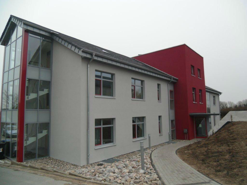 Modernes, dreistöckiges Firmengebäude in weiß-roter Fassade
